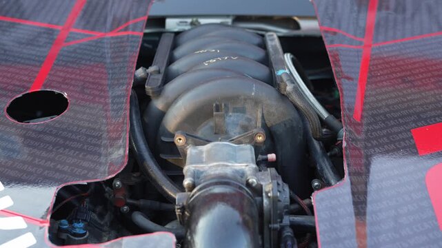  Close-up view of a car engine visible through custom hood.