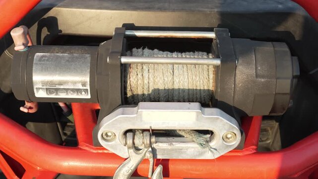 Close-up of a rugged electric winch mounted on off-road vehicle.
