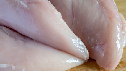 Fresh chicken breast fillet on the wood bread for cooking. © Iryna