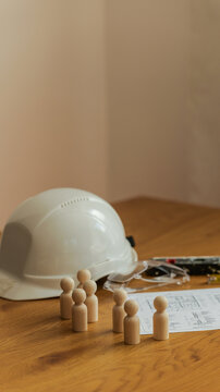 Construction team planning with blueprints and safety gear on wooden table