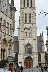 Fototapeta premium Tower of Saint Bavo Cathedral Above Cobbled Square in Ghent