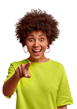 Excited young African American woman with afro hair pointing at camera with a joyful expression