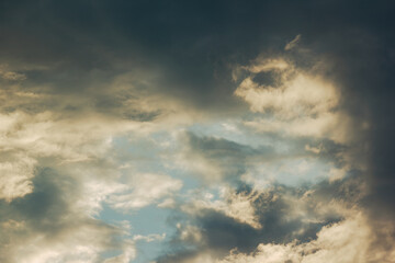 Obraz premium Dramatic cloudy sky with warm sunlight breaking through storm clouds