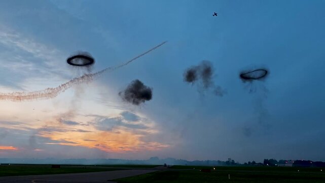 Aerobatic stunt aircrafts performing spectacular aerial maneuvers in the sky, releasing colorful smoke and fireworks. Team formation flight with white smoke trails. 4K video footage