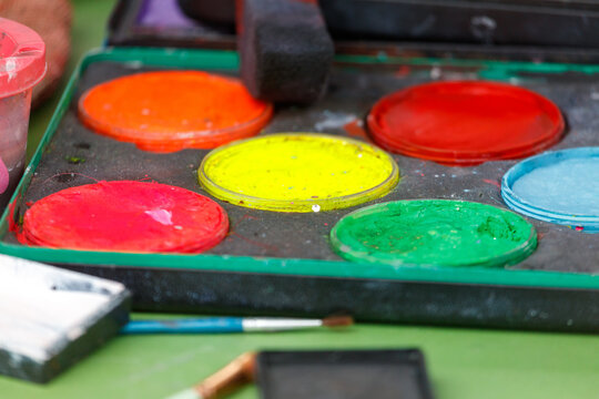 Colorful paint pots sit in a tray