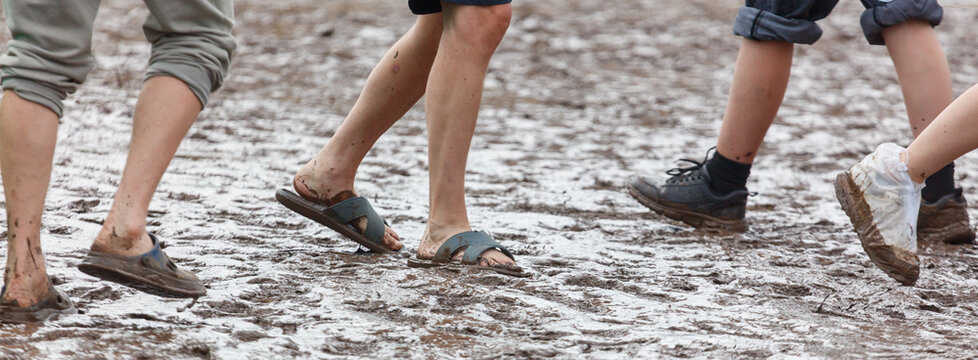 Person walks through wet, muddy ground in sandals