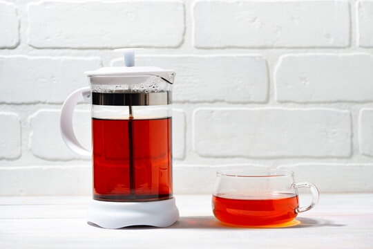 fresh black tea in French press on white background