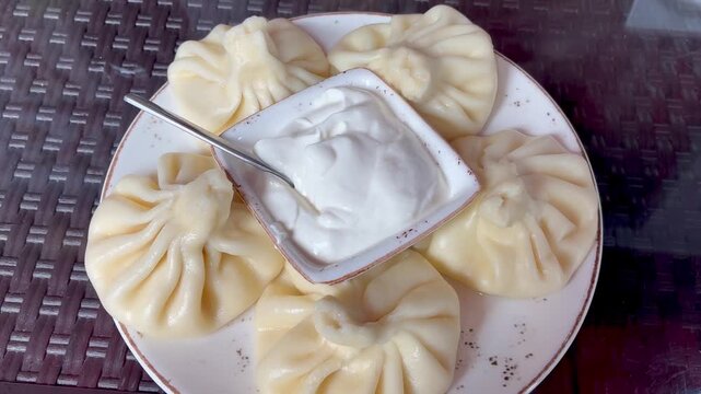 Close up of traditional georgian khinkalies dumplings with soar cream top view