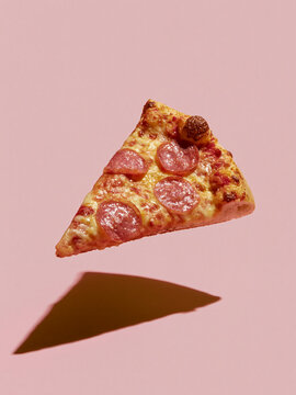 Floating pepperoni pizza slice with shadow on pink background