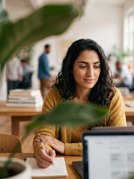 Middle Eastern woman working at desk in modern office