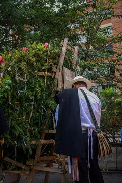 Traditional silleteros carrying flower arrangements during a cultural festival parade
