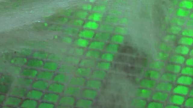 Glimpse inside a sophisticated hydro air filtration system. A constant flow of purifying water dances across an illuminated green mesh, capturing impurities and refreshing the air quality.