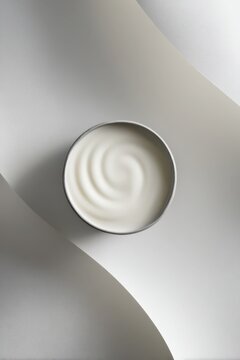 Craft mug filled with white yogurt on bright white background with light shadows showing depth and texture