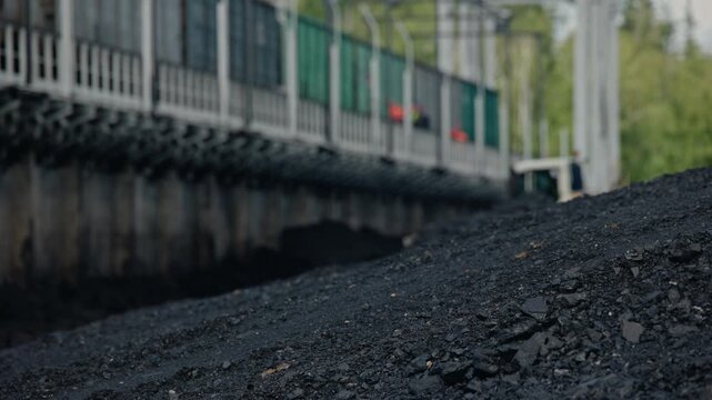 Excavator unloads freight car loaded with coal, mining industry.
