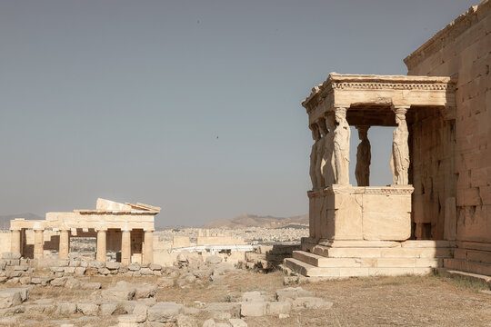 The Erechtheion and Parthenon stand atop the Acropolis of Athens, Greece, showcasing classical marble architecture and the artistry of ancient civilization.