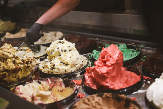 A gelato counter displays vibrant tubs of creamy flavors including chocolate, pistachio, and strawberry, capturing the indulgent charm of Mediterranean desserts.