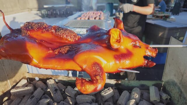 Whole Roast Suckling Pig Rotating on Charcoal Spit for Mid-Autumn Festival Barbecue