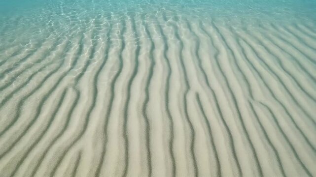 Crystalline shallow water with rippled sand pattern underneath