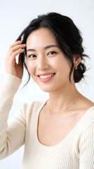 Naklejka premium Portrait of a beautiful young asian woman with a friendly smile wearing a casual beige sweater