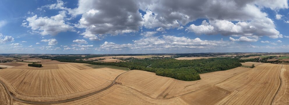 vue a&eacute;rienne panoramique des champs apr&egrave;s la moisson. Paysage rural et agricole en Meurthe-et-Moselle, Lorraine. Ciel bleu avec des gros nuages cumulus en &eacute;t&eacute;. France 2026
