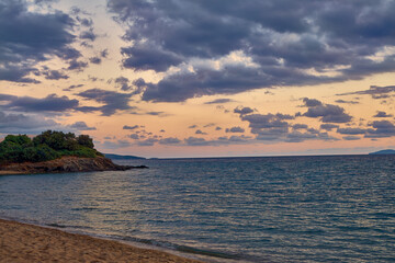 Obraz premium Dramatic Cloudy Sunset Over a Calm Mediterranean Beach