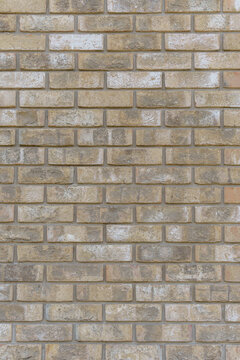 A yellow brick wall texture with a rustic and textured background. A vertical surface of aged masonry blocks with vintage industrial interior design elements.