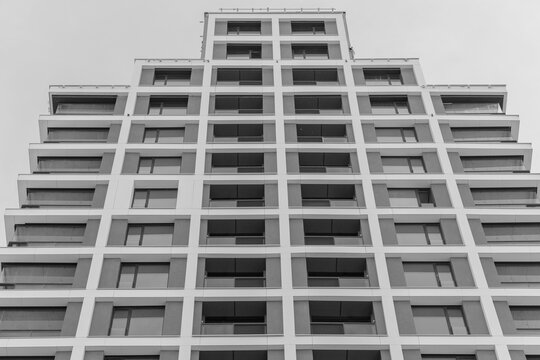 A modern residential building facade with geometric stepped terraces. 