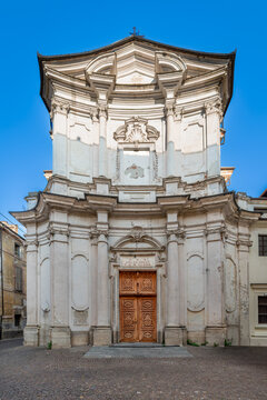 Cuneo, Italy: elegant concave Baroque facade of former Church of Santa Chiara. Architectural masterpiece features historical white stone columns, ornate decorations and  carved wooden entrance door 