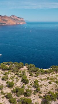 Calanques National Park landscape Mediterranean sea with vegetation and tourist boats. Aerial view