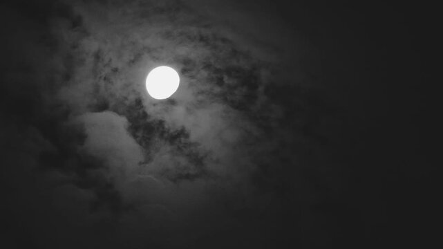 Tokyo,Japan - August 2, 2026: The moon shining beyond Moving thin clouds