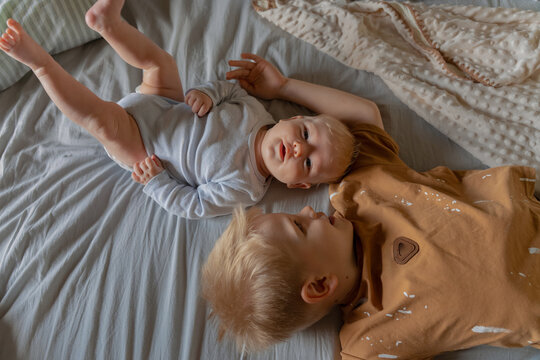 Two brothers lie together on bed during childhood