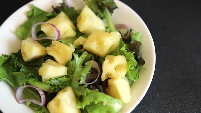Pineapple Salad mixed green salad leaves and pineapple chunks food preparation tasty snack fresh gourmet food background on the table rustic food top view copy space keto and paleo diets vegetarian an