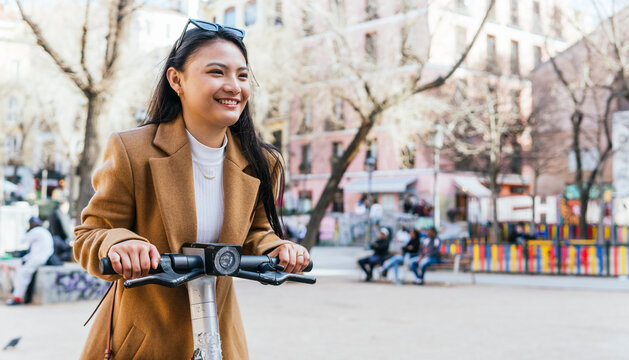 Woman enjoying a scooter ride in an urban setting