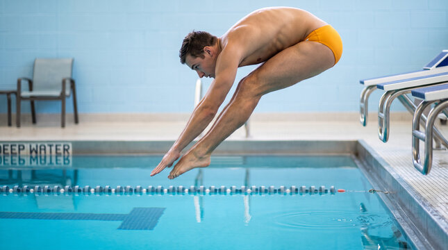 Man diving into swimming pool from the edge with focus on form  