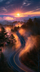 Obraz premium misty road emerging into sunrise light, serpentine asphalt through morning fog, ethereal dawn landscape with winding road