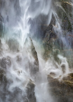 Misty Yosemite waterfall rushing over granite rocks