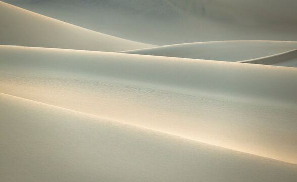 Minimalist sand dunes in Death Valley at soft sunrise light