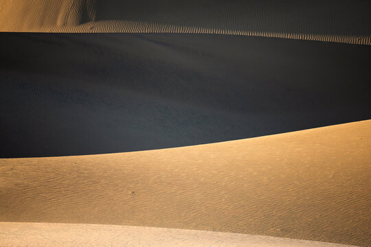 Sunlit sand dunes and shadow patterns in Death Valley desert