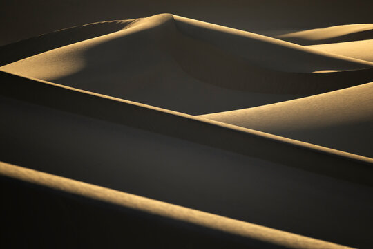 Sunlit sand dune ridges in Death Valley desert landscape