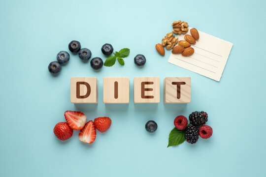 Healthy diet concept with word diet on wooden blocks, fresh berries, nuts and blank paper on blue background