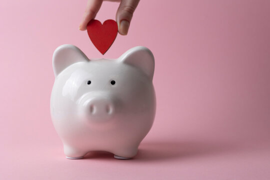 Piggy bank with red heart symbol, savings and financial goals concept