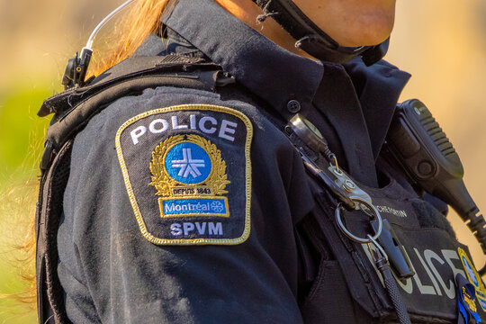 Montreal, QC, Canada. Aug 1, 2026. Close up view of Montreal SPVM police officer shoulder patch and official uniform badge outdoors.