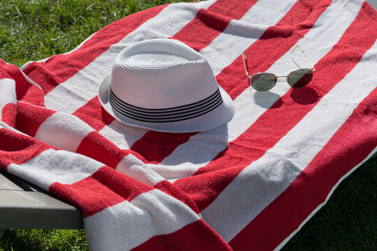 Summer beach towel with straw hat and sunglasses