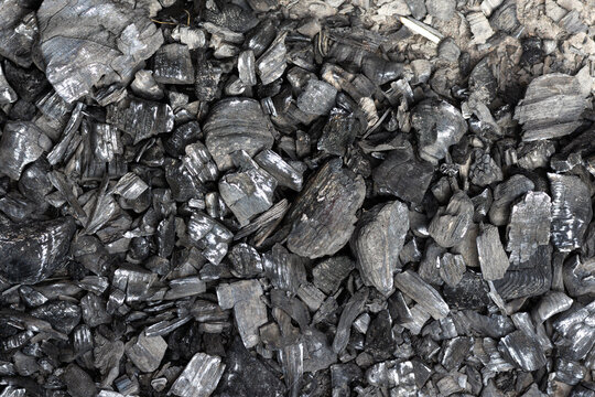 Close-up texture of charcoal pieces and ash background