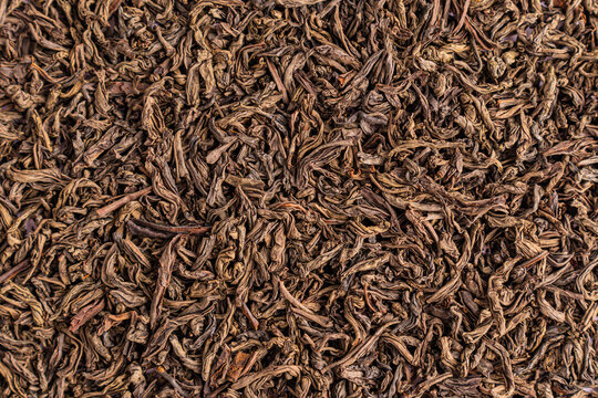 Dried loose leaf black tea texture background closeup