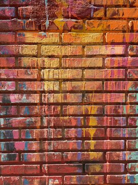 Colorful paint drips on weathered red brick wall