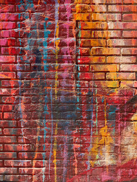 Colorful graffiti paint on weathered urban brick wall