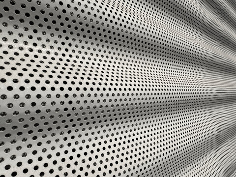 Abstract perforated metal surface with curved dot pattern