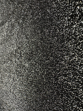 Black textured surface with shimmering silver speckle