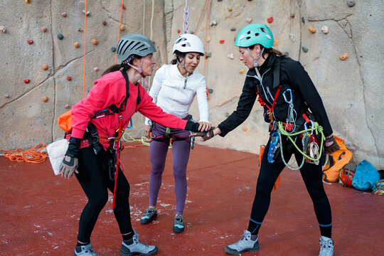 Women prepare for vertical caving training at indoor gym